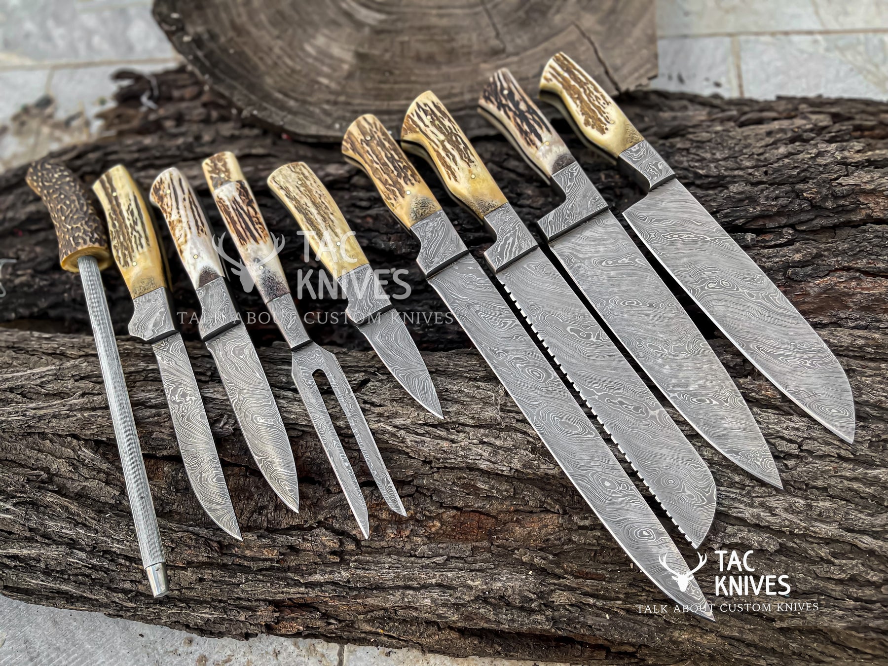 A set of custom handcrafted knives with patterned Damascus steel blades and natural antler handles, arranged on a rustic log background. The brand 'Tac Knives' is visible as a watermark and logo overlay.